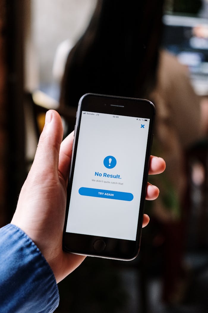 Hand holding a smartphone displaying a No Result notification, emphasizing technology usage.